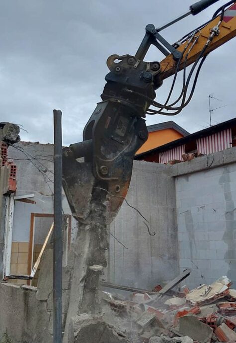 refort-demolizioni-fabbricati-e-ripristino-braccio-demolitore-con-frantumatore-flessibile-adagia-al-suolo-blocco-cemento